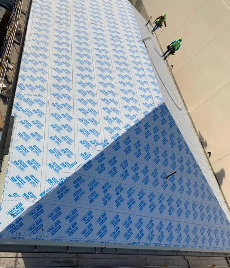 Professional roofers installing underlayment on a metal roof in Newport News